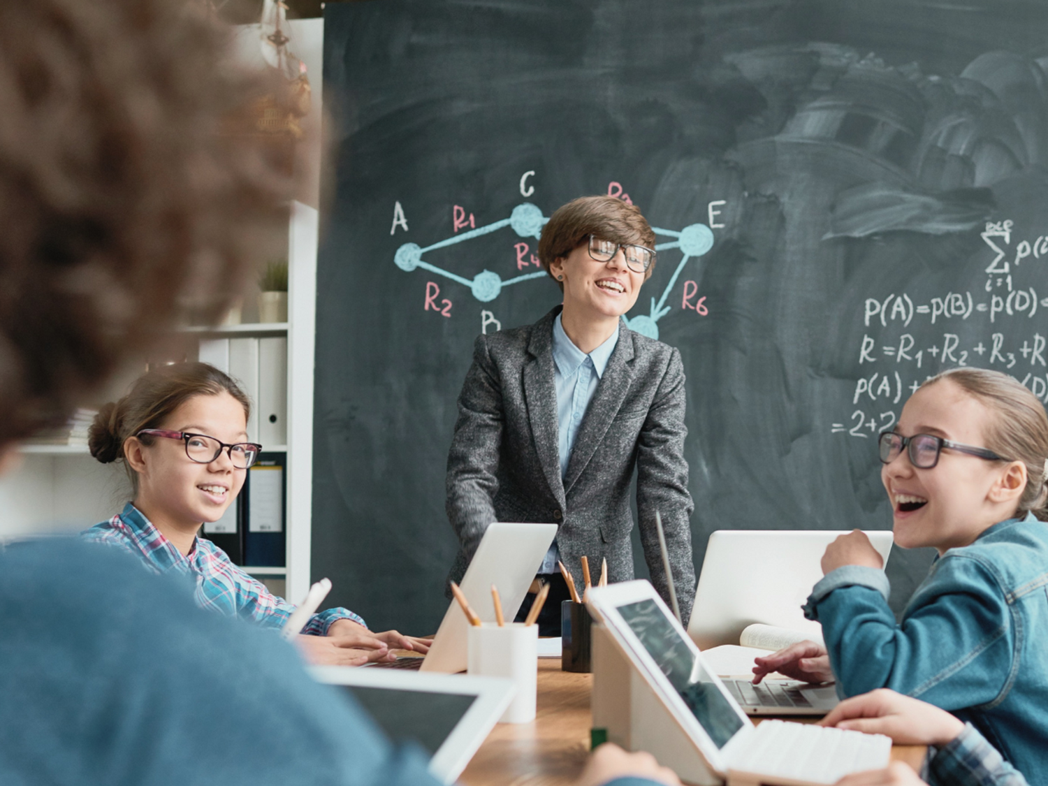 A teacher at the front of the classroom talking to students.