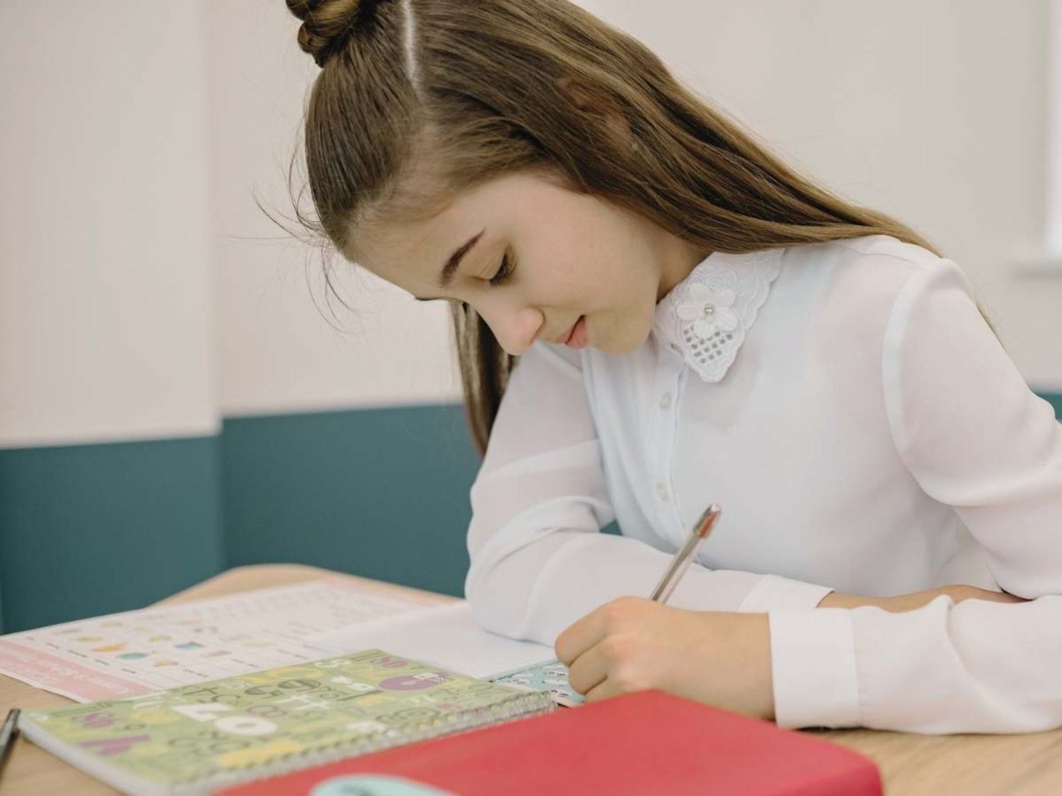 A learner reading and writing in a classroom