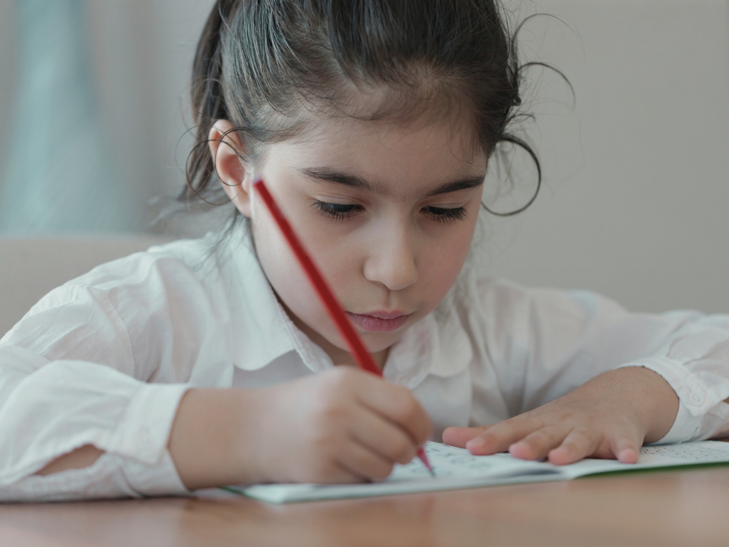 A student learning academic vocabulary and writing on paper.