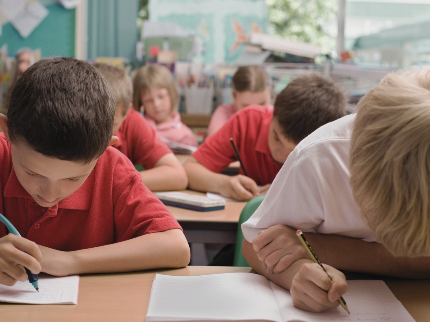 Primary pupils writing in the classroom