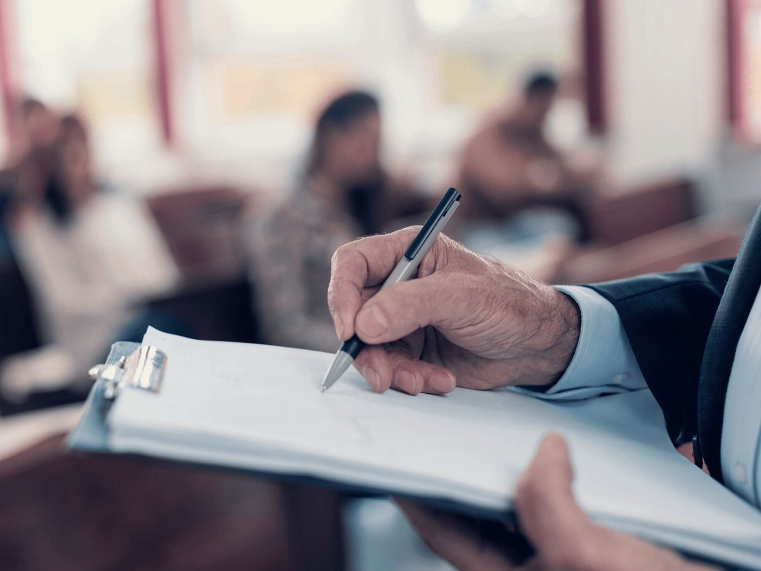 A teacher writing while watching a class of students