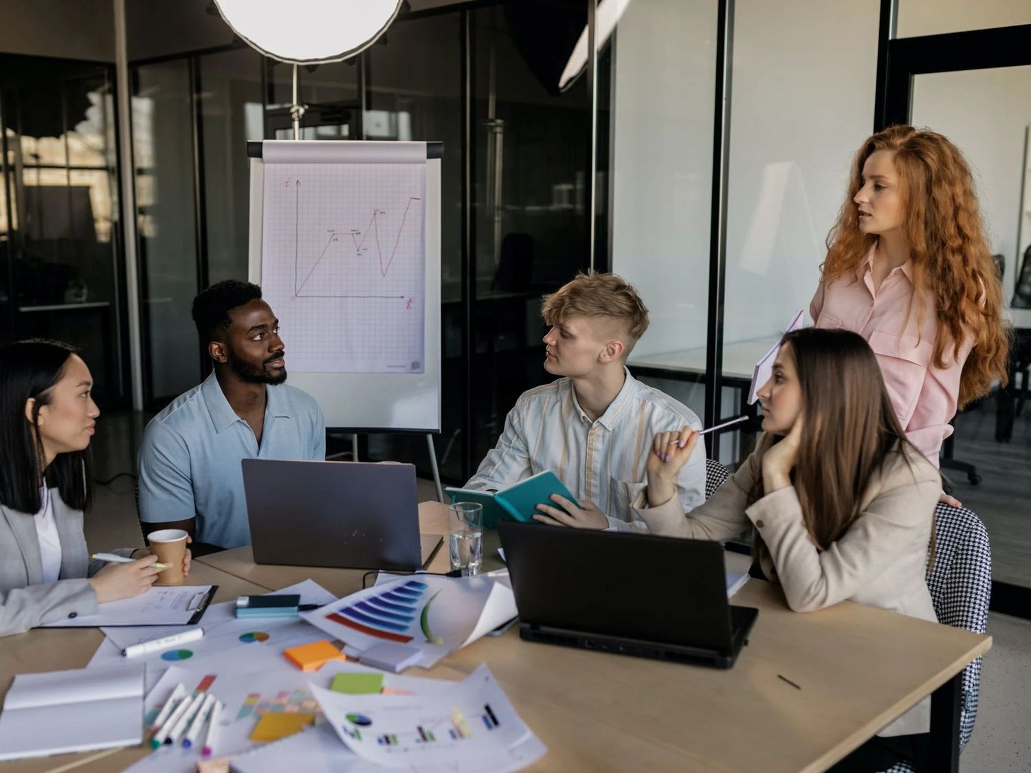 Five people collaborating on strategy around a table