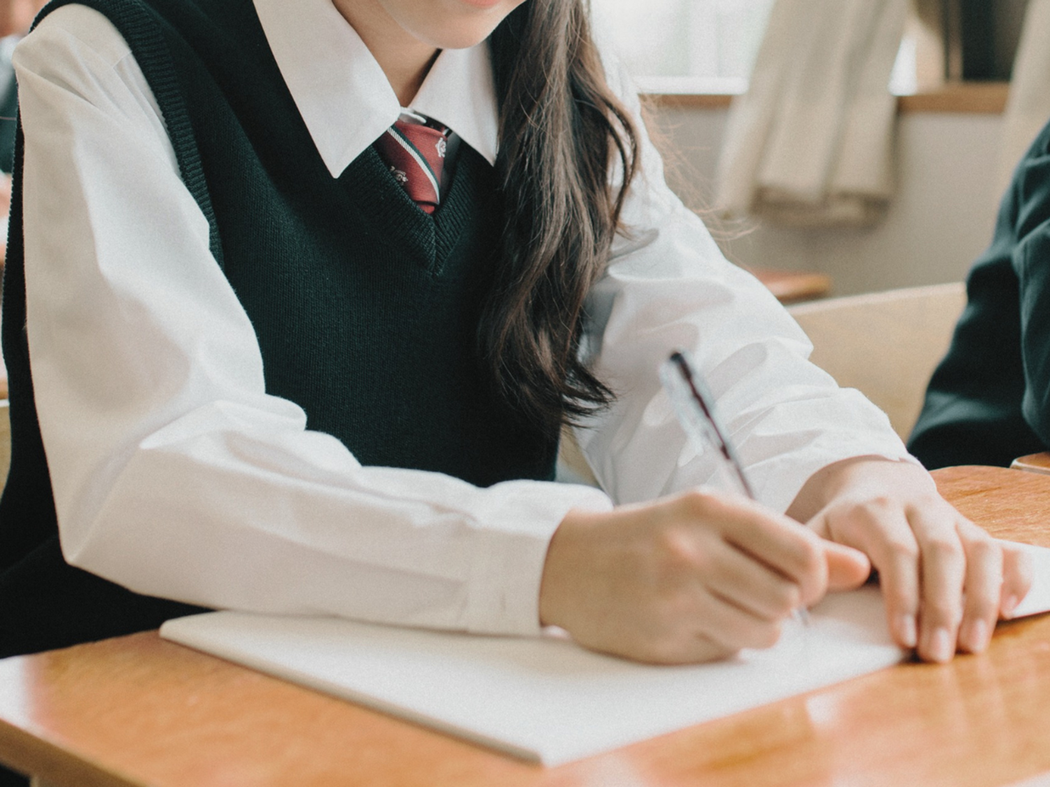 A student writing in the classroom